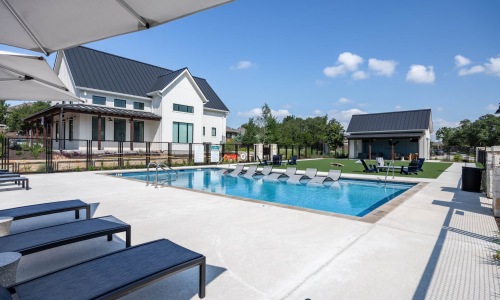 Swimming pool surrounded by sun loungers and modern buildings