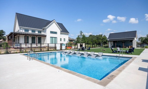 Sparkling pool with in-water loungers and nearby green space